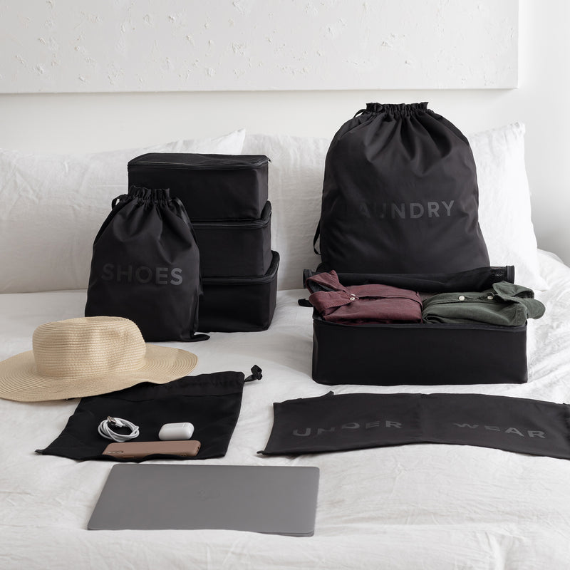 Packing organizer set in black on top of a bed