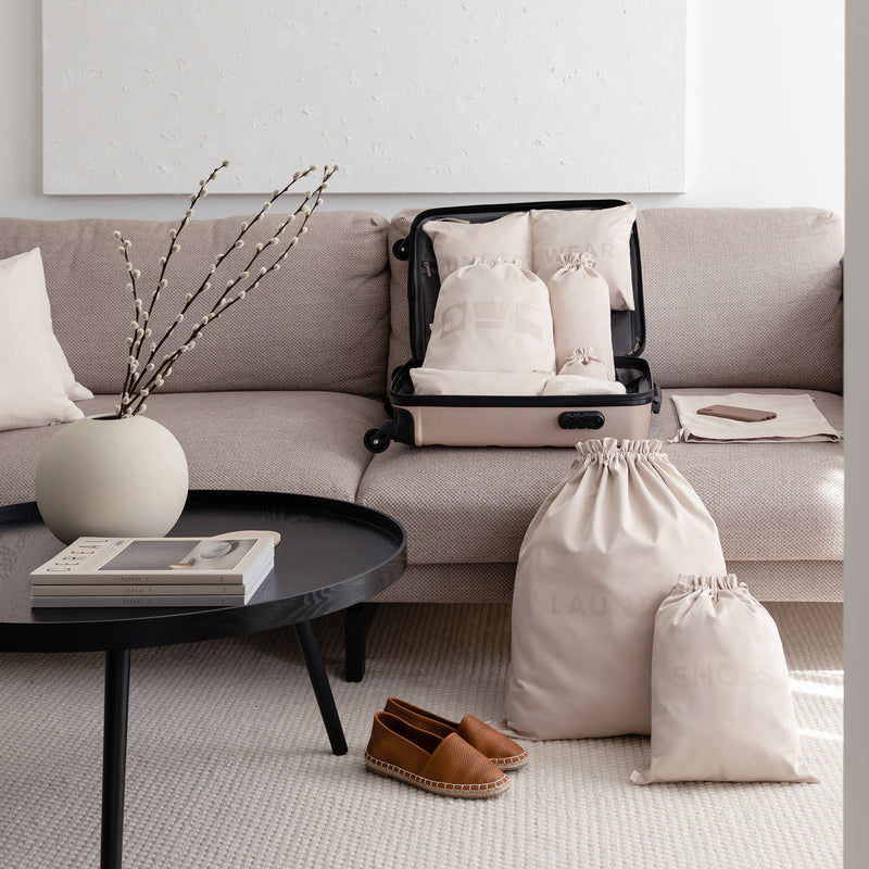 Extra large laundry bag in the color beige in a living room