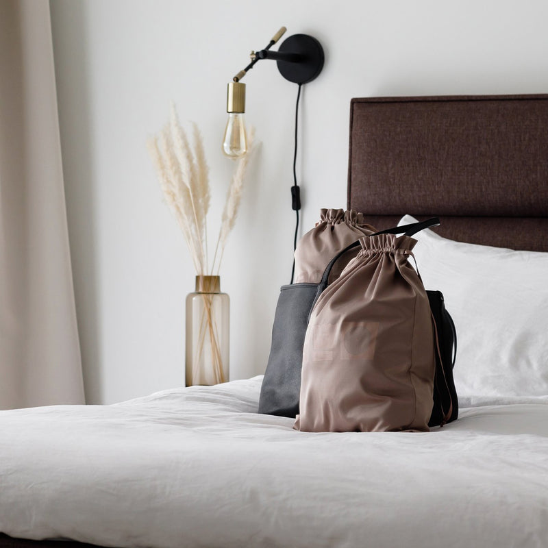 Large brown laundry bag on top of a bed